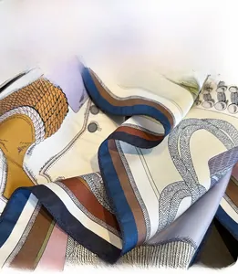 Detailed close-up of premium silk scarf featuring delicate triangular stitched edges