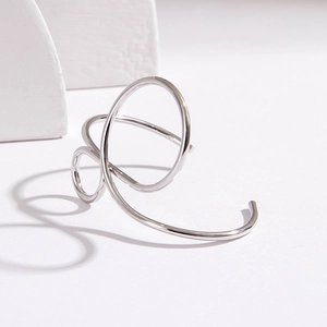 Macro view of minimalist silver hollow geometric bangle with polished curved metal lines