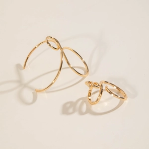 Detailed view of minimalist gold hollow geometric bangle and matching open ring set