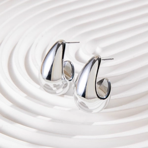 Macro detail of high-polish silver drop earrings with smooth metallic mirror finish