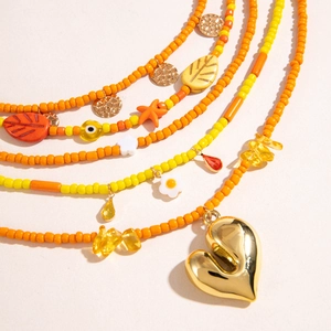 Detailed close-up of Bohemian layered beaded necklace with a golden heart pendant