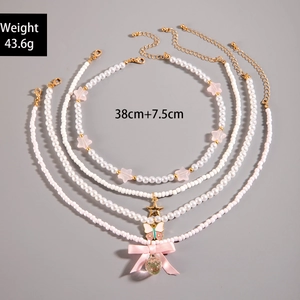 Detail of 4-piece necklace set with faux pearls, pink stars, and butterfly charms