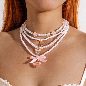 Y2K layered beaded necklace with strawberry, butterfly charms and pink ribbon bow