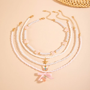 Y2K beaded choker set with strawberry and butterfly charms on pink background