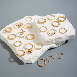 Ensemble de 20 bagues dorées avec motifs lune, étoile et serpent sur support en pierre