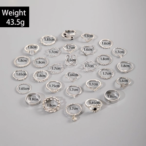 Ensemble de 24 bagues gothiques argentées aux motifs de serpent et de coeur sur fond gris