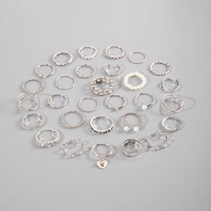 Détail à plat d'un ensemble de bagues gothiques argentées avec breloques cœur et perles
