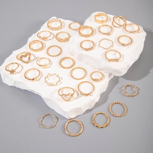 Détail de l'ensemble de bagues dorées avec des motifs de cœur, d'étoile et LOVE