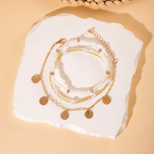 Detalle del conjunto de tres tobilleras bohemias con lentejuelas doradas y cuentas finas