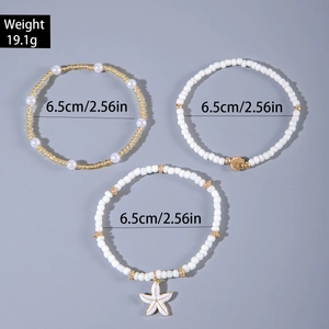 Detalle del conjunto de pulseras bohemias de cuentas con dijes de estrella de mar y caracol
