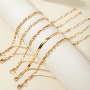 Detalle de un juego de cinco pulseras doradas con cierres de mosquetón y extensiones