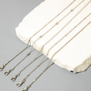 Primer plano detallado del conjunto de 5 tobilleras bohemias plateadas sobre piedra