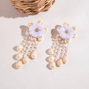 Detalle de pendientes de flor de concha con borlas de perlas para estilo de playa