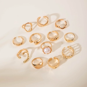 Close-up of 12-piece gold geometric ring set with pearl and irregular textures