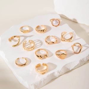 Detailed macro view of 12-piece vintage gold ring set with irregular pearls and geometry