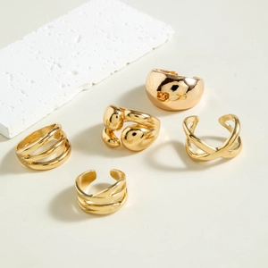 Detailed close-up of a five-piece minimalist chunky gold ring set with polished finishes