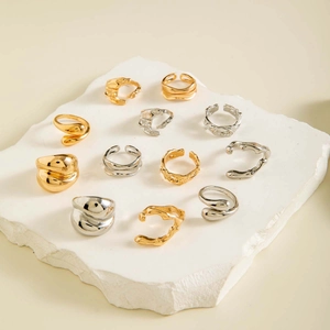 Detail of 11-piece set featuring irregular liquid metal rings in gold and silver finish
