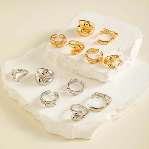 Macro view of twelve minimalist irregular lava rings in gold and silver finish
