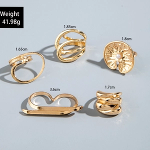 Detailed view of 5-piece gold geometric ring set with pearls and wave textures