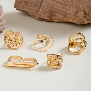Close-up of a 5-piece gold-toned ring set with faux pearls and geometric designs