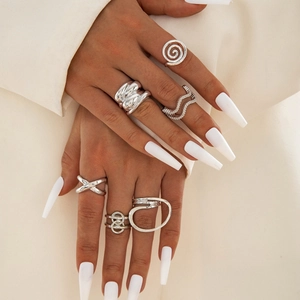 Close-up of a silver ring set featuring spiral, wavy, and geometric metal textures on hand