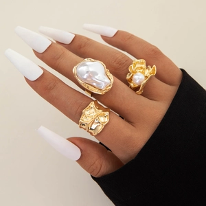 Set of three gold baroque pearl rings featuring irregular textures and pleated metal designs
