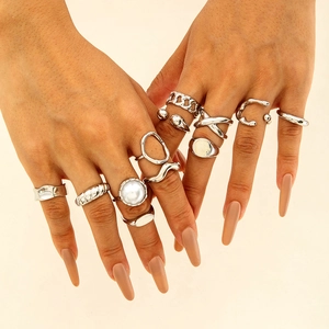 Detailed close-up of 11-piece vintage silver rings set with pearls and chains on hands