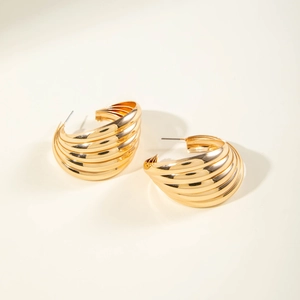 Detailed close-up of chunky gold geometric layered hoop earrings with polished finish