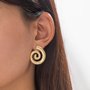 Detailed close-up of golden spiral geometric stud earring with vintage stripe texture