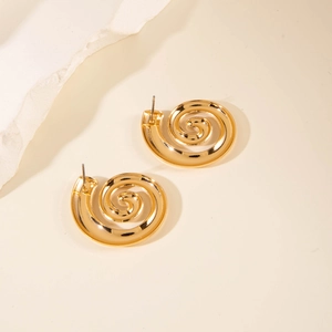 Detailed view of golden spiral textured metal stud earrings with a glossy artistic finish