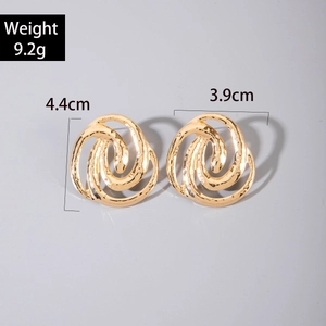 Detailed view of large gold layered spiral hoop earrings with hammered metal texture