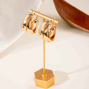 Detailed view of chunky triple-hoop gold earrings with a polished mirror finish