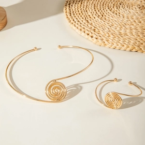 Golden swirl choker and bangle set with minimalist spiral design and round accents
