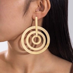 Close-up of oversized triple-ring gold geometric earrings on model for modern style