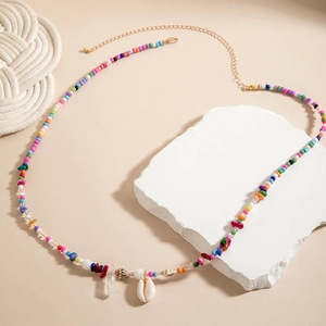 Detail of colorful beaded waist chain with natural shells on a white stone background