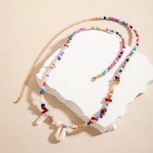 Macro detail of colorful beaded waist chain with a white shell and crystal pendant