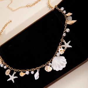 Close-up of beach style waist chain with white pearls, starfish charms and natural seashells