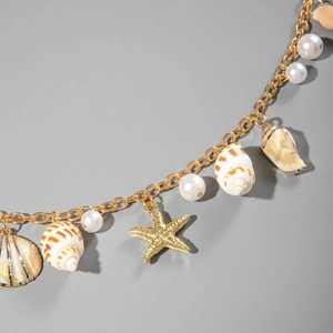 Detailed close-up of beach style waist chain with gold sea star and shell pendants