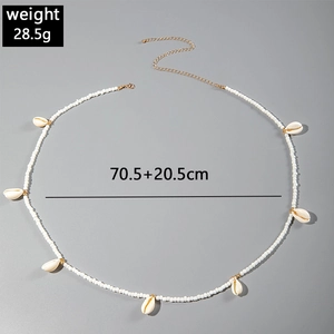 Detail of beach waist chain with white beads, natural shells and gold lobster clasp