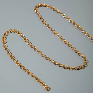 Close-up of a polished gold metal chain with round links for beach body jewelry set