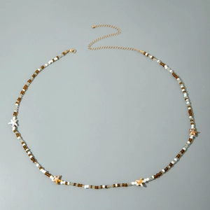 Detail of beaded beach body chain with starfish pendants and golden lobster clasp