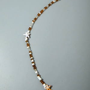 Detail view of beach style waist chain with brown beads and starfish charms