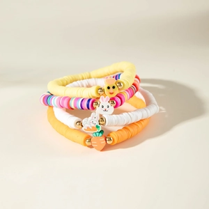 Dettaglio di braccialetti colorati in argilla con ciondoli a forma di coniglio