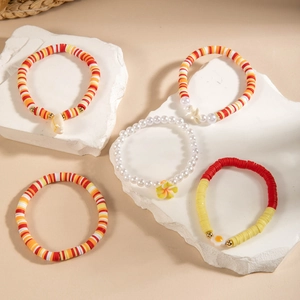 Dettaglio set braccialetti bohémien con perline Heishi colorate e ciondoli a stella marina