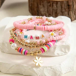 Dettaglio del bracciale multistrato stile oceano con lettere MAMA e ciondolo a fiore