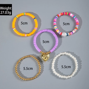 Dettaglio set di braccialetti bohémien con perline colorate in argilla e ciondoli a conchiglia