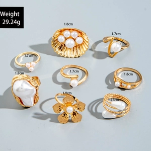 Detailansicht eines 8-teiligen Vintage-Ring-Sets in Gold mit Perlen, Blumen und Maßangaben