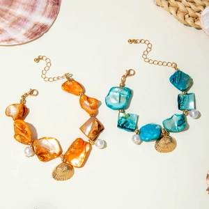 Detail of ocean-themed seashell bracelets with starfish charms and adjustable gold chain