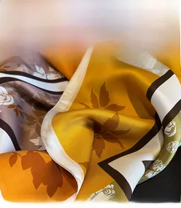 Close-up of premium silk scarf featuring delicate hand-rolled edges and floral prints