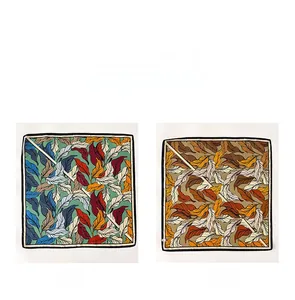 Detail view of double-sided silk scarf showing contrast leaf patterns in green and brown